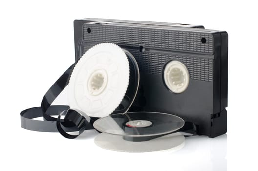 Two videotapes and reel on  white reflective background.
