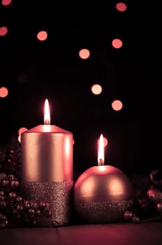 Christmas candles set against black background.