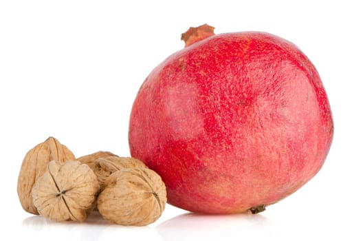 Ripe pomegranate fruit and nuts isolated on white background.