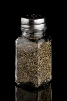 Oregano shakers on black Background.