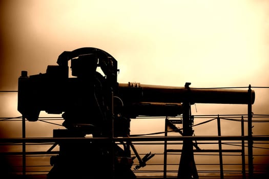 The side view and the surreal depiction of a gun on a warship.