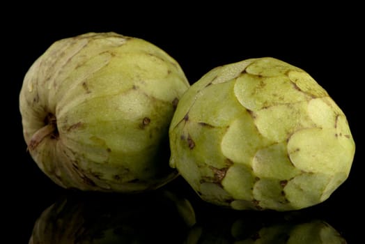 Custard apple, also known as Bullocks or Bulls Heart.On black with reflection.