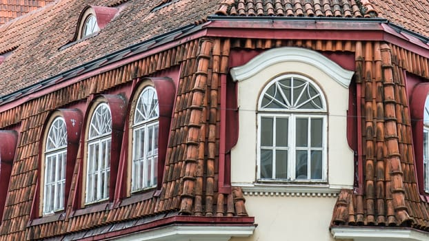 Mansard windows on a tile roof of the house in Tallinn, a close up