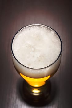 Close-up of a beer glass with foam on the table