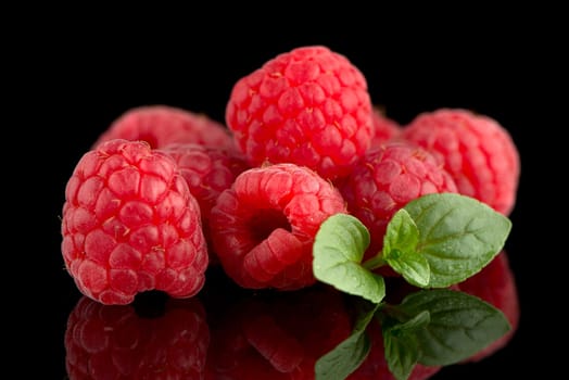 Raspberries with leaves isolated on black background background
