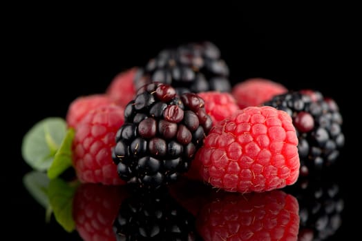 Composition from a blackberry and raspberry on the black isolated background