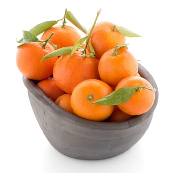 Tangerines on clay bowl isolated on white background