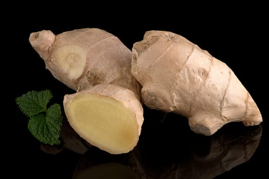 Ginger root on black reflective background.