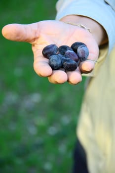 beautiful smiling woman showing fresh olives
