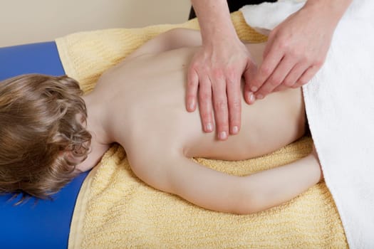 a female physiotherapist makes physiotherapy with young children