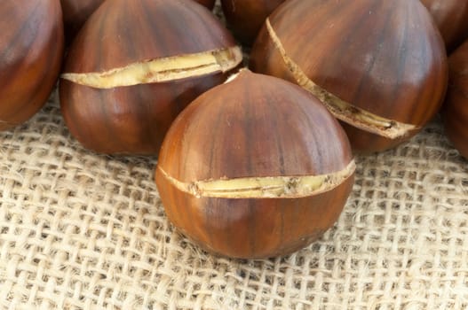 raw natural macro of chestnuts in jute background