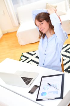 View of a young smiling business woman relaxing at work