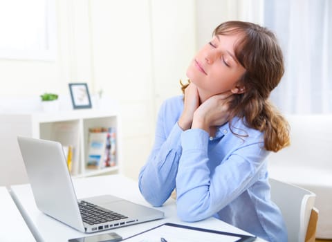 View of a young smiling business woman relaxing at work