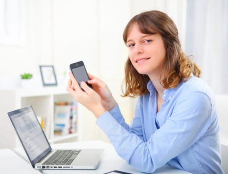 View of a young business woman writing a text on her mobile