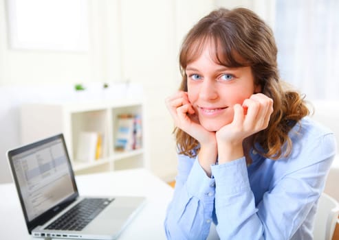 View of a young smiling business woman at work