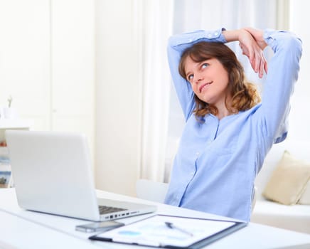 View of a young smiling business woman relaxing at work