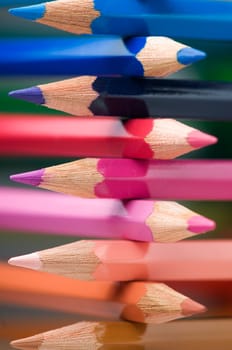Close-up of cross stacked crayons in the colours of the colour circle with selective sharpness