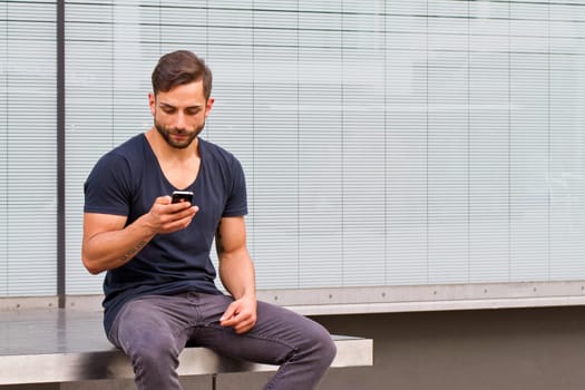 Young man in the city writes a text message