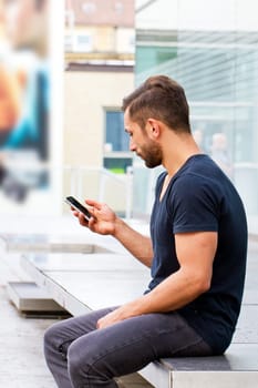 Young man in the city writes a text message