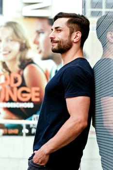 Young man in the city - In the background a promotional poster