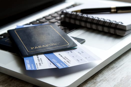 Airline tickets over the keyboard of a laptop.