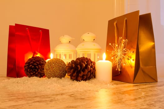 Christmas setting with candles, pine cones, shopping bags and baubles..