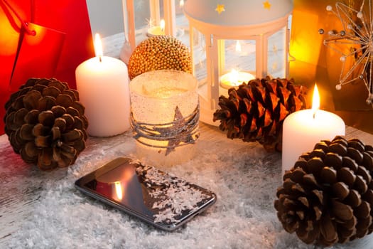 Christmas setting with candles, pine cones, shopping bags and baubles..