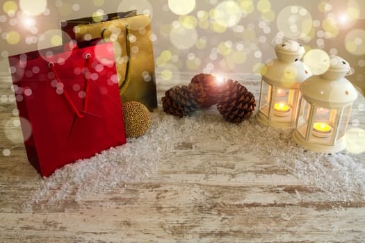Christmas setting with candles, pine cones, shopping bags and baubles..