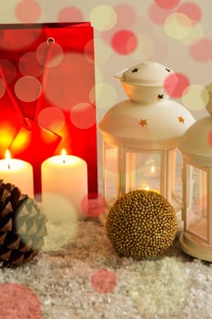 Christmas setting with candles, pine cones, shopping bags and baubles..
