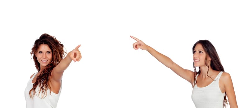 Two young pretty girls indicating something isolated on a white background