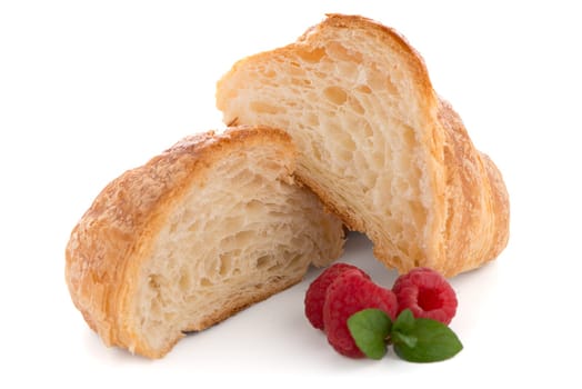 Fresh croissant and raspberries on white background