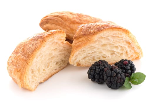 Fresh croissant and blackberries on white background