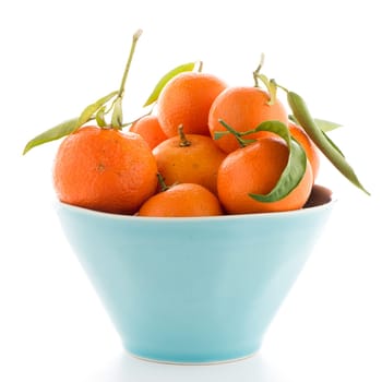 Tangerines on ceramic blue bowl  isolated on white background