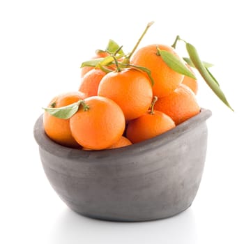 Tangerines on clay bowl isolated on white background