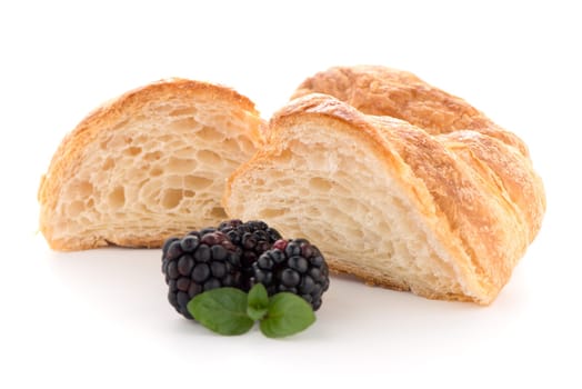 Fresh croissant and blackberries on white background