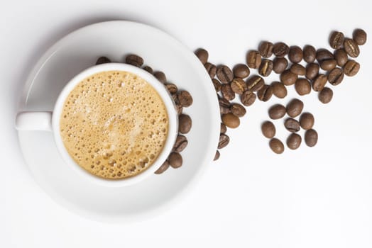 Delicious breakfast cup of coffee top view with foam and roasted bean decoration. Clipping path included, so you can easily copy and paste it on your own design.