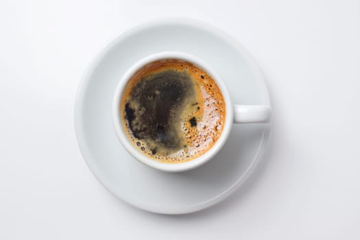 Single cup of coffee top view with plate, empty white background. Clipping path included, so you can easily copy and paste it on your own design.
