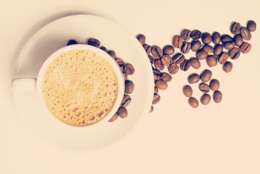 Delicious breakfast cup of coffee top view with foam and roasted bean decoration. Clipping path included.