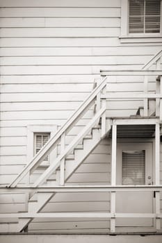 A wooden staircase at a house with board cladding.