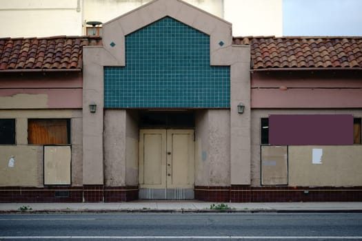 A run-down theatre with snaked windows and a yellowed facade.