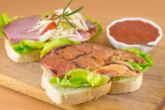 the making of a double sandwich on a cutting board
