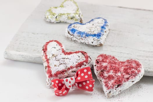 Heart shaped sweet cookies on a white wooden board
