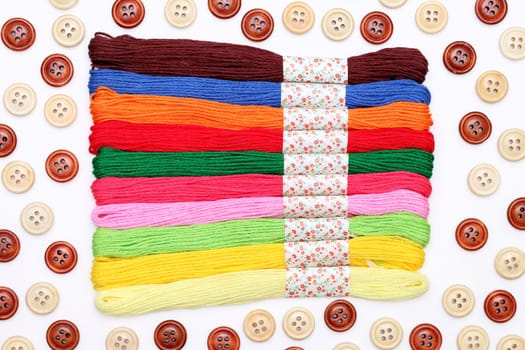Sewing buttons and threads on white background
