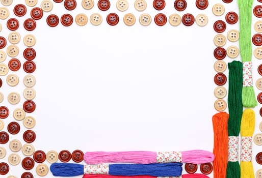 Sewing buttons and threads frame on white background