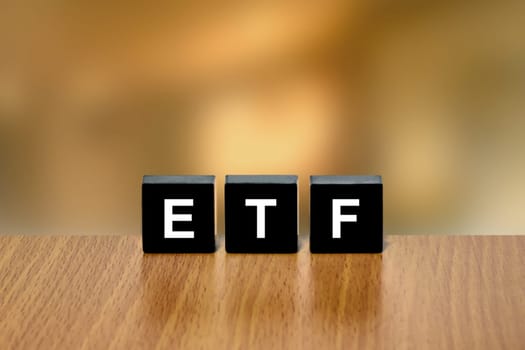 ETF or exchange traded fund on black block with blurred background