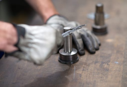 workers hand measuring a metal workpiece