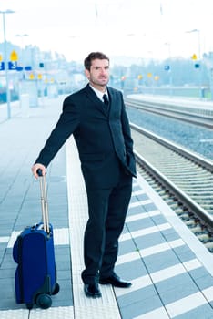 businessman in dark suit on railroad station