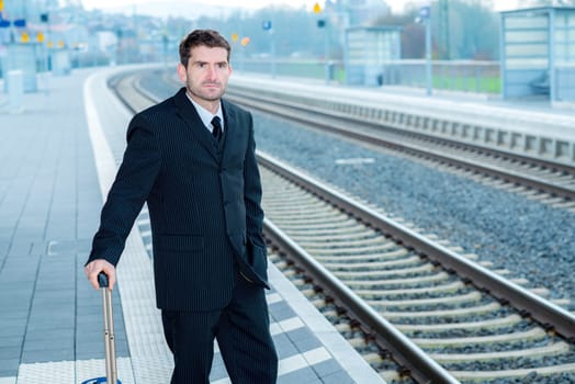 businessman in dark suit on railroad station