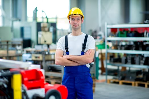 worker in work clothes with yellow helmet in factory