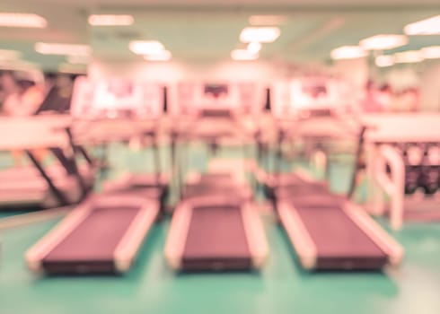 Interior of modern fitness center with equipment. Blur abstract background image in retro filtered color.